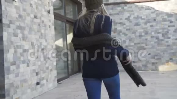 穿暖和衣服的漂亮女孩在院子里散步和摆姿势4K视频的预览图