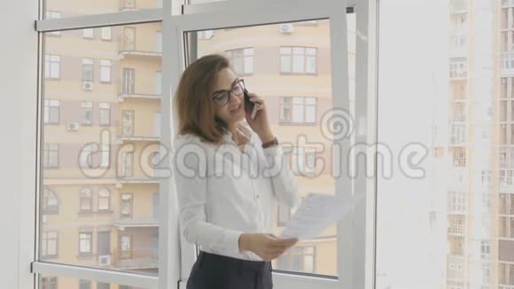办公室工作人员女商人在办公室里看文件打电话视频的预览图