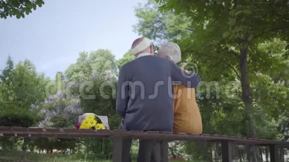 一对恋爱中的成熟夫妇坐在公园的长凳上的肖像成年妇女和老人在一起投标视频的预览图