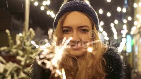 一幅欢快的漂亮女人的肖像手里拿着闪闪发光的东西星团向不同方向散射视频的预览图