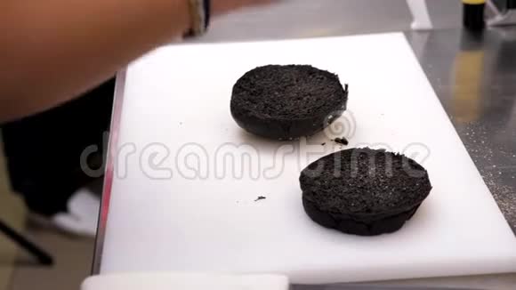 烹饪双手调味料准备一个黑色汉堡包视频的预览图