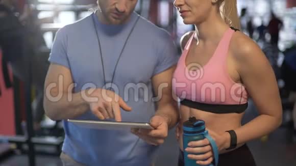 健康夫妇在健身房讨论锻炼计划确定未来的健身目标视频的预览图
