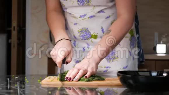 切割鳃女性用一把大刀在木切割板上切割鳃视频的预览图