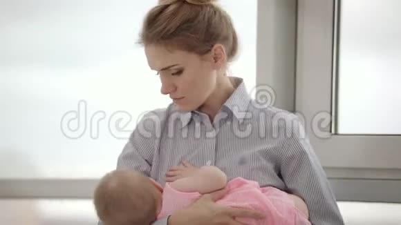 疲惫的母亲手牵着孩子靠近窗户累女人抱着孩子视频的预览图