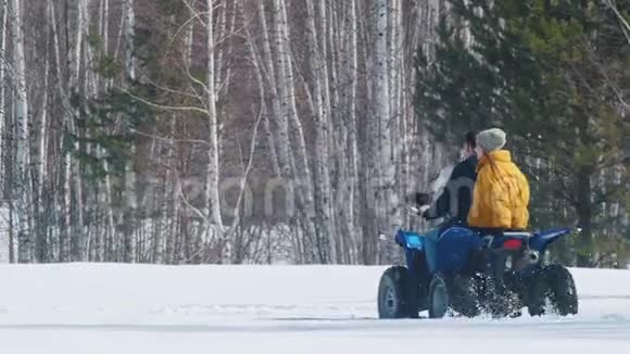 人们穿着明亮的冬天的衣服在森林里骑着雪地摩托视频的预览图