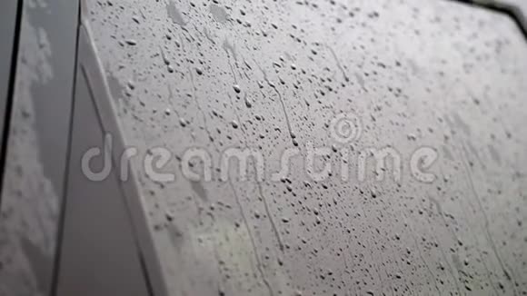 特写车上的玻璃窗上滴下的雨滴滴下了许多溪流下大雨倾盆大雨视频的预览图