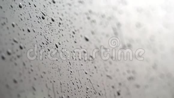 特写车上的玻璃窗上滴下的雨滴滴下了许多溪流下大雨倾盆大雨视频的预览图