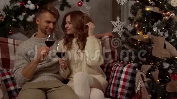 年轻夫妇在家一起过圣诞节在家概念喝酒聊天视频的预览图