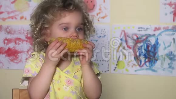 小女孩在玉米棒上吃着乱七八糟的玉米视频的预览图