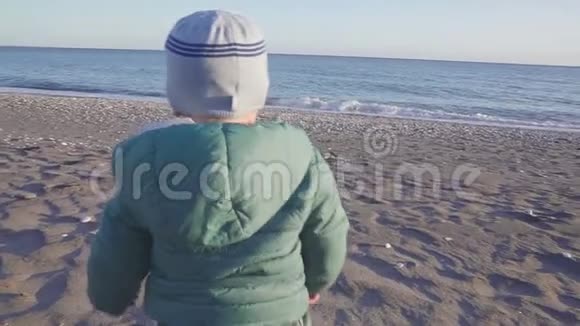 宝宝的生活方式那个男孩在日落时跑到海里假日概念慢动作与斯泰西卡姆视频的预览图