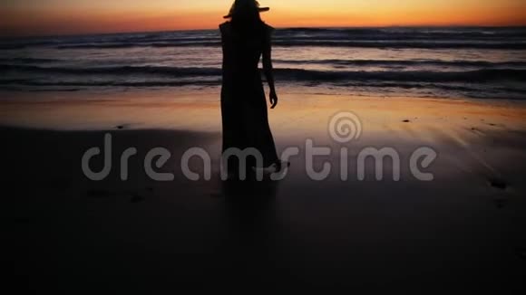 心在沙滩上女人正在用腿写字走在夕阳的沙滩上视频的预览图