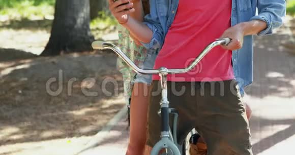 骑自行车的情侣使用手机视频的预览图