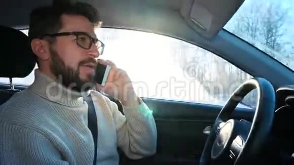 冬天一个人在城市之间的公路上开车他在说智能手机视频的预览图