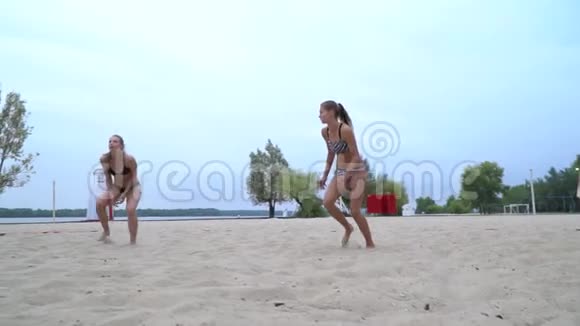 跳着球年轻女子打沙滩排球视频的预览图