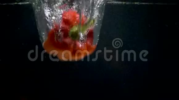 黑色背景下在水中落下的甜椒的足迹视频的预览图