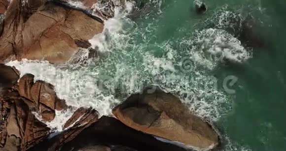 从空中俯瞰在石头上破碎的波浪视频的预览图