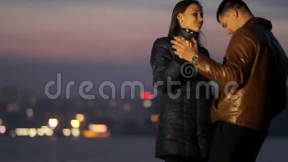 快乐的恋人在夜城的背景下拥抱和跳舞温柔的爱浪漫的夜晚视频的预览图