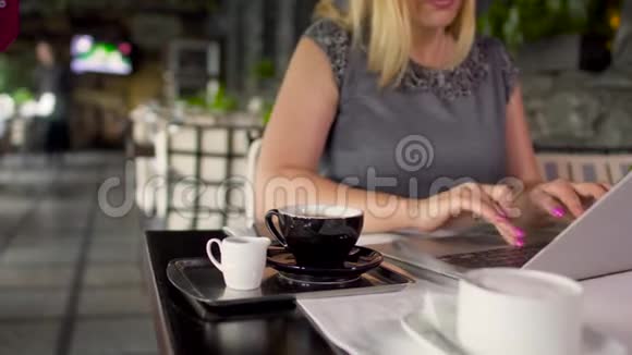 一位穿着灰色衣服的成年女性在餐厅里坐在桌上打字视频的预览图