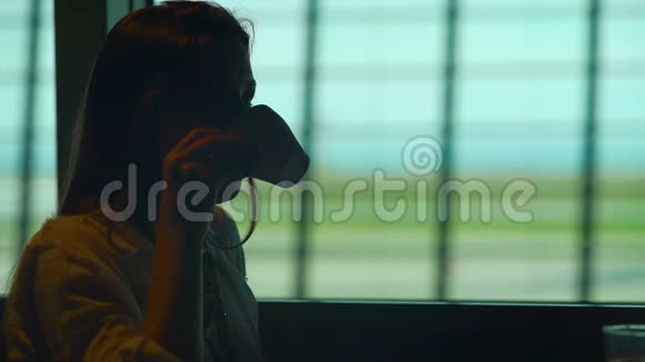 体贴的女性在机场喝咖啡等待她的飞机视频的预览图