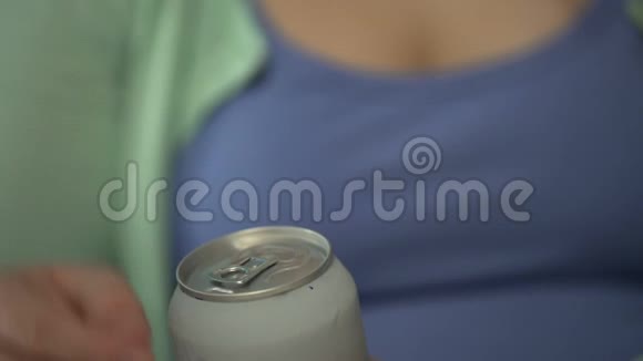 青少年打开罐头喝汽水含糖饮料特写视频的预览图