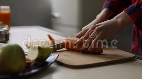 女性手在砧板上切生胡萝卜视频的预览图