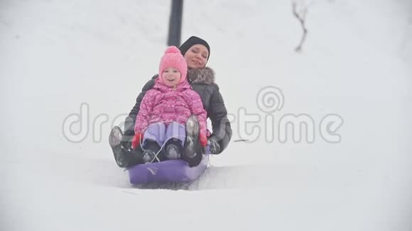 带着母亲在雪地里雪橇的笑孩子视频的预览图