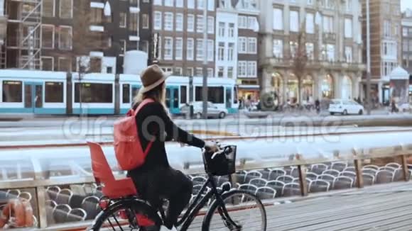 学生女孩骑自行车沿着河流码头当地的通勤者戴帽子的女人骑着城市自行车巡游慢动作视频的预览图