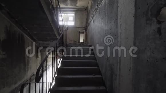 在黑暗中爬上恐怖的楼梯一个人在恐怖的楼梯间爬上黑暗而危险的楼梯视频的预览图