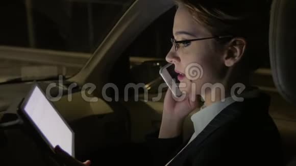 车里的女商人在打电话她在夜路上坐在车里视频的预览图