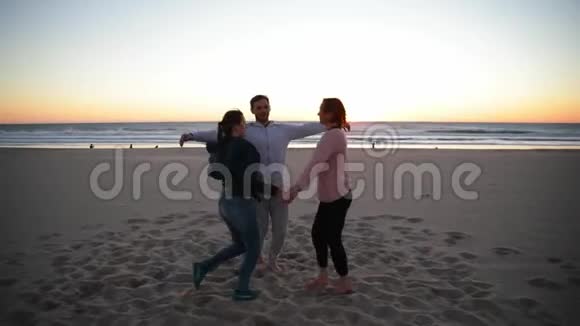 在海滩上和教练一起练习瑜伽人们互相拥抱视频的预览图