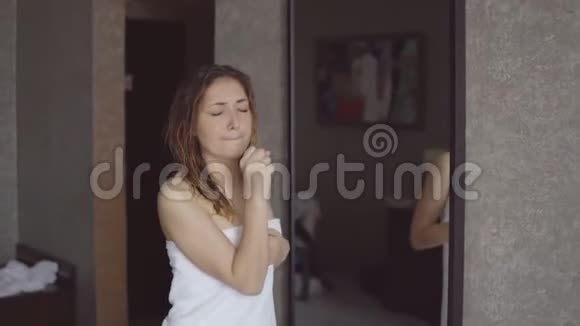 漂亮的女孩站在毛巾前洗澡后在镜子前唱歌跳舞视频的预览图