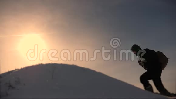 商务人员的团队合作三个登山者在一座白雪覆盖的小山上一个接一个地爬商务人员团队视频的预览图
