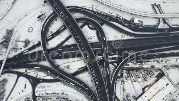 冬天汽车在公路立交桥上行驶顶景雪道交叉口视频的预览图