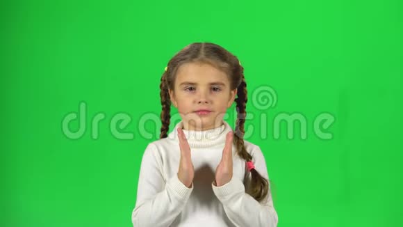 可爱的女孩在绿色背景上拍手视频的预览图