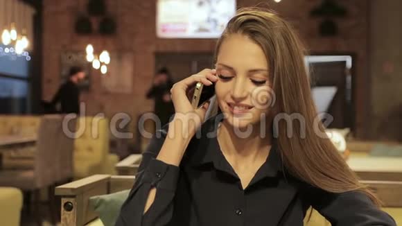 女商人在咖啡馆里谈论智能手机视频的预览图