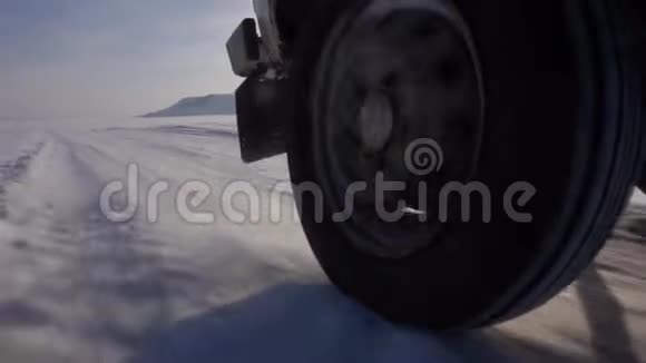 骑在湖面的冰上和很多雪汽车的后轮视频的预览图