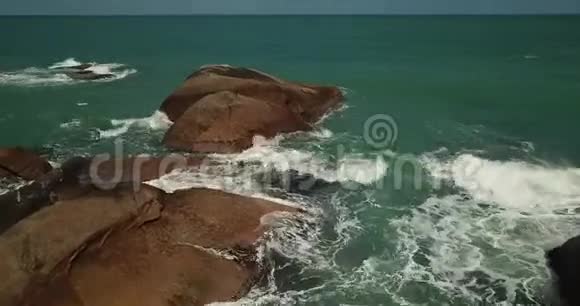 从空中俯瞰在石头上破碎的波浪视频的预览图