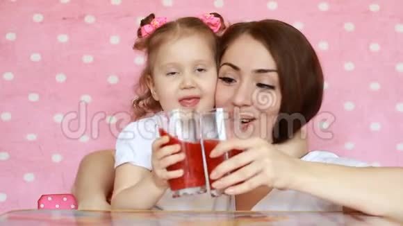 母女俩正喝着冰沙笑眯眯的年轻的女人和她的孩子一起享受一杯清爽可口的饮料粉色视频的预览图