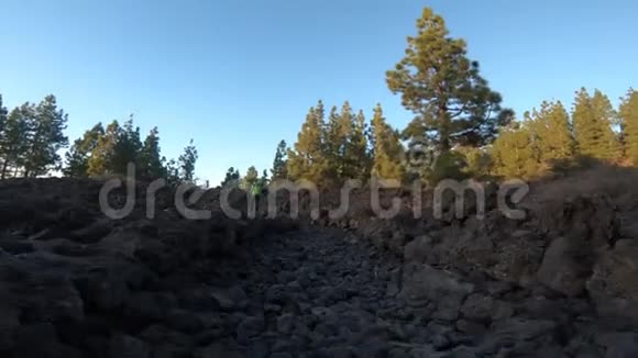 徒步旅行者穿越火山土壤和岩石的低水平镜头视频的预览图