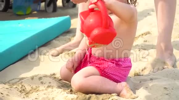 在沙滩上玩水壶的女孩视频的预览图