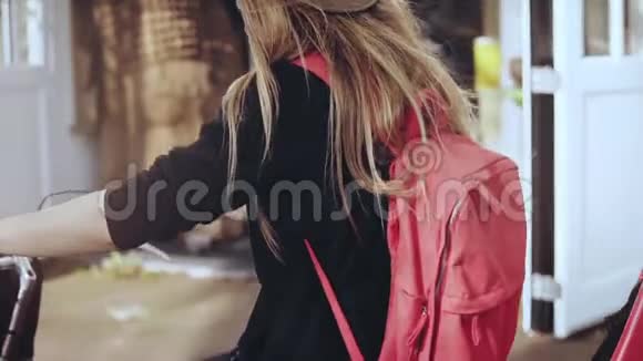 女性骑着一辆带红色背包的自行车慢动作极端特写相机上下倾斜骑自行车的女人视频的预览图