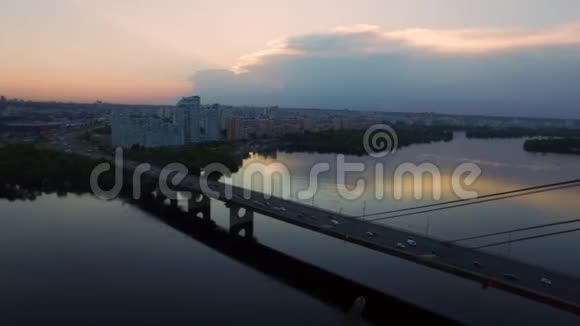 傍晚的城市景观中在河上的悬索桥上驾驶台可以看到汽车交通视频的预览图