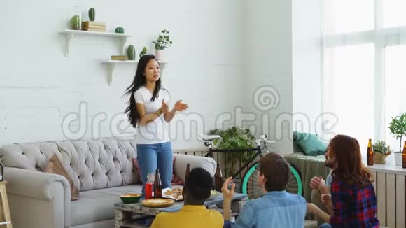 年轻的亚洲女孩在家里和她的多民族朋友玩聚会游戏视频的预览图