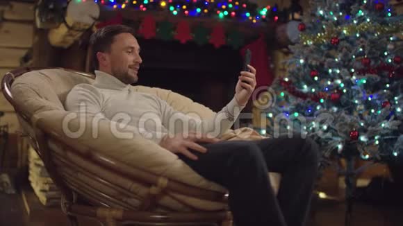 圣诞之夜成人男子在笔记本电脑上讲电视电话视频的预览图