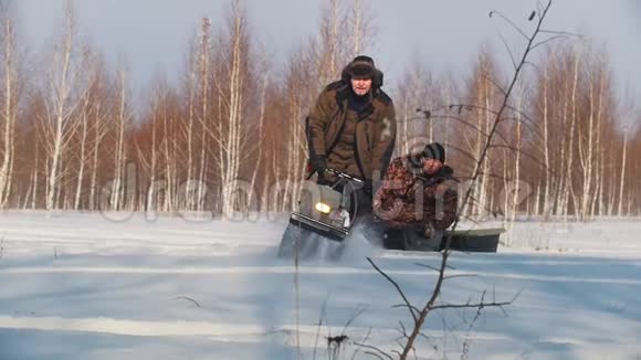 穿冬装的成年男子在小型雪地车拖车上快速骑行载客视频的预览图