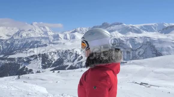 山坡上戴头盔护目镜的特写肖像女子滑雪者视频的预览图
