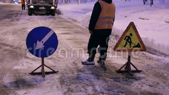 雪犁把雪从城市街道上移走工人安装警示路标视频的预览图