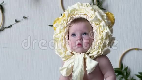 漂亮的婴儿在摄影特写镜头前戴着黄色头饰的姿势视频的预览图