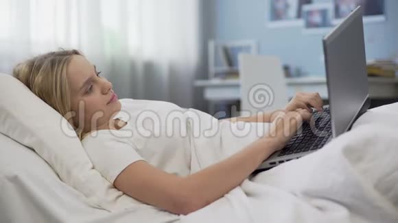 微笑的青少年在社交网络中交流躺在床上早上的时间视频的预览图