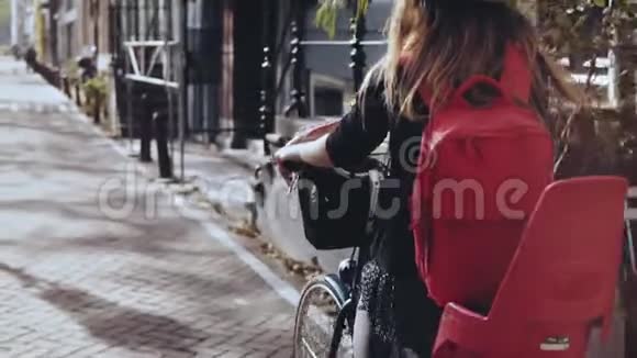 女孩骑自行车和一个可爱的紫色花罐波夫慢动作生活方式博客女士在一个快乐的城市自行车之旅视频的预览图